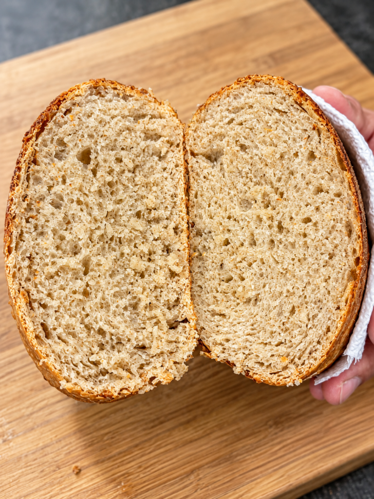 Homemade sourdough loaf sliced in half showing the interior crumb.